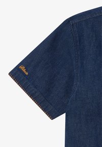 Dark blue denim shirt sleeve with orange stitching and embroidered logo. Features a classic cut and a textured fabric.