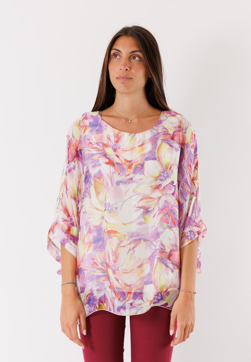 Blusa floreale con un motivo multicolore di grandi fiori, tessuto leggero e trasparente, maniche ampie e scollatura rotonda.