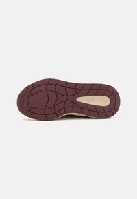 Talpa de pantof cu un model texturat în burgund profund, cu striuri și un accent neted de culoare crem, etichetat "Guess".