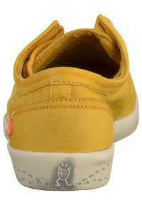 Scarpa in pelle gialla con forma arrotondata, anelli posteriori, superficie testurizzata, suola in gomma bianca e accenti grigi con logo.