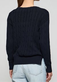 Pull en maille torsadée bleu marine avec ourlet et poignets côtelés, fabriqué à partir d'un matériau texturé. La vue arrière met en avant les détails de conception finement tissés.