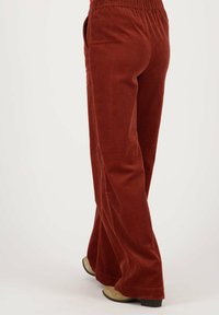 Corduroy wijde broekspijpen in roestkleur met verticale ribbels, elastische tailleband en zijzakken. Casual ontwerp met een ontspannen pasvorm.