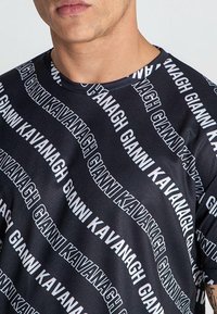 Crna majica kratkih rukava s ponavljajućim bijelim uzorkom teksta "Gianni Kavanagh", s okruglim izrezom i glatkom tekstilnom teksturom.