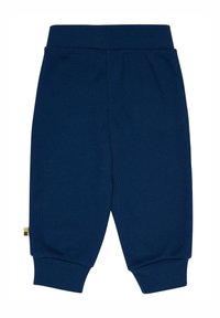 Navyblaue Waffelstrickhosen mit einem breiten elastischen Bündchen, schmal zulaufenden Bündchen und einem kleinen mehrfarbigen Etikett auf der linken Seite.