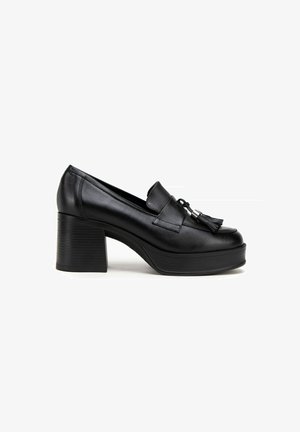 Zwarte leren platform loafers met een ronde neus, een decoratieve kwast en een chunky, ribbelige hoge hak. Gladde textuur overal.