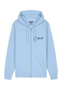 Haut de survêtement zippé bleu clair en tissu doux, doté d'une poche avant et d'un graphisme en écriture noire portant le mot "Liberté" sur la poitrine gauche.
