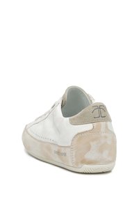 Weiße Sneakers mit einem glatten Lederobermaterial, beigen Wildlederakzenten an der Ferse und einer strukturierten Gummisohle. Subtiles Logo-Detail auf der Rückseite.