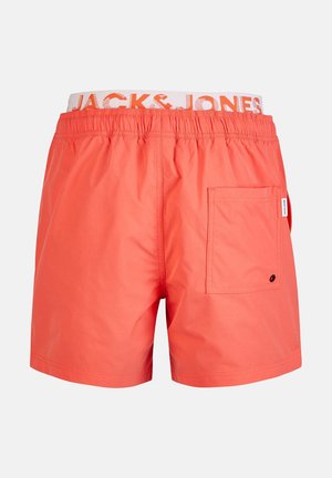 Coral swim shorts with an elastic waistband featuring "JACK & JONES" logo. Includes a side pocket, made from lightweight fabric.