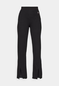 Pantaloni di stoffa nera con vita alta, caratterizzati da spacchi laterali all'orlo e un piccolo logo ricamato sul lato sinistro superiore.