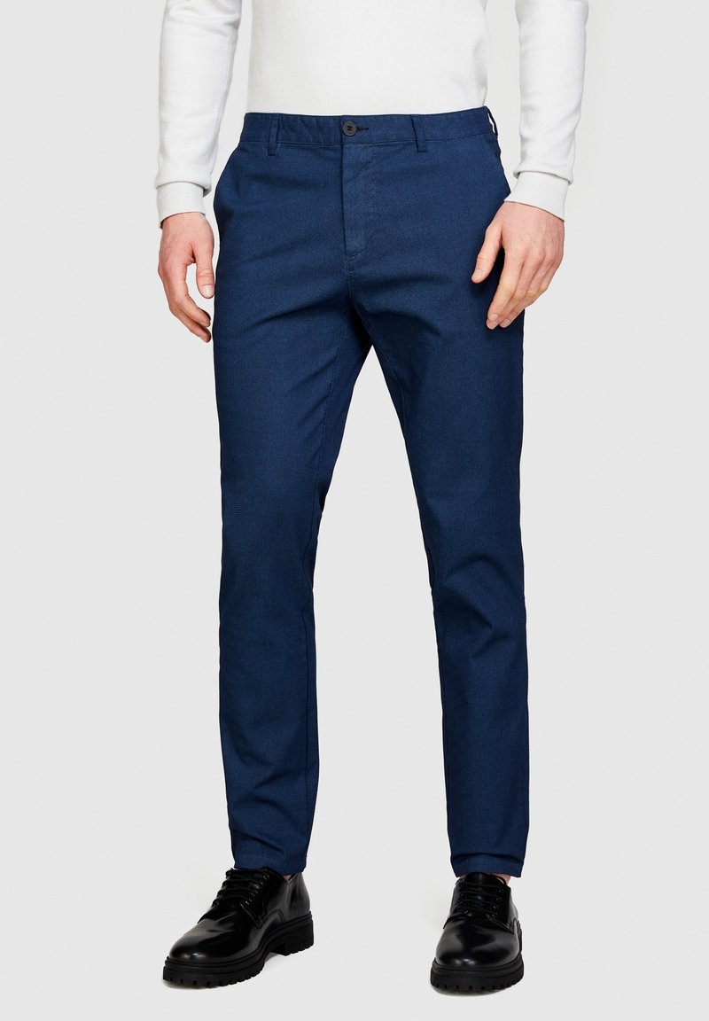 Chinos bleu marine en tissu texturé, dotés d'une fermeture à bouton, d'une coupe slim et de poches latérales. Associés à des chaussures noires à lacets.