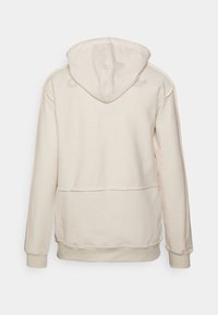 Ljusbeige hoodie i mjuk tyg. Har en dragsko på huvan, ribbade muddar och en synlig logotyp på baksidan. Enkelt mönster, inga mönster.