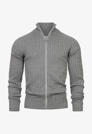 Grå ribbestrikket genser med glidelås og høy krage, med en smal passform og lange ermer. Glidelåsen er sølvfarget og fremhever stoffets tekstur.