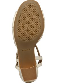 Suela de sandalia Geox en un tono beige claro con un patrón de goma texturizada, que presenta pequeñas perforaciones para la transpirabilidad y un talón reforzado para mayor soporte.