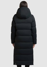 Černý péřový kabát s dlouhou, oversized kapucí, prošívanou konstrukcí a bočními větracími zipy, navržený pro teplo a izolaci.