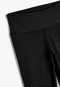 Leggings neri in tessuto elasticizzato, con una vita alta e cuciture piatte per il massimo comfort. Texture liscia senza pattern o accenti.