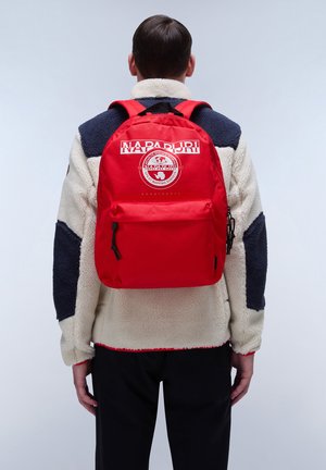 Roter Rucksack mit einem Logo-Patch auf der Vorderseite, verstellbaren Trägern und einer Reißverschlusstasche. Gefertigt aus strapazierfähigem Stoff, mit einer glatten Textur und funktionalem Design.