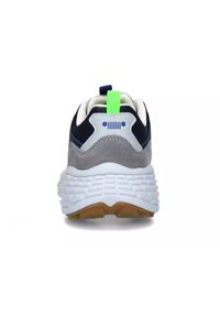 Vista posteriore di una sneaker con tomaia in suede grigio e blu navy, suola imbottita bianca e una linguetta verde brillante. Suola texturizzata per una buona aderenza.