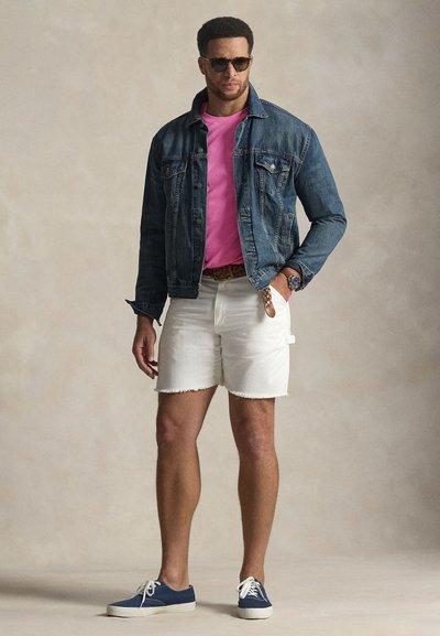 Τζιν μπουφάν, ροζ μπλούζα, λευκά σορτς και μπλε αθλητικά παπούτσια. Διαθέτει γυαλιά ηλίου και υφαντή ζώνη. Καθημερινό καλοκαιρινό outfit.