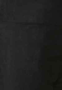 Black faux suede fabric with a soft texture, featuring a seamless design and subtle stitching details along the edges.