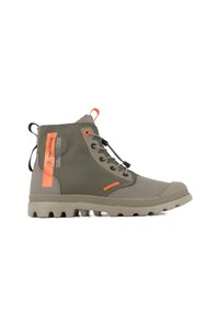 Botas de caña alta en color verde oliva y beige, con suela gruesa, cordones en la parte delantera, tiradores naranjas y marca naranja en el lateral.