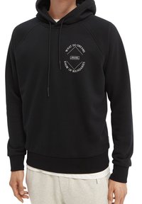 Sort hættetrøje med snøre og raglanærmer. Har et hvidt trykt motiv på brystet i en cirkulær opstilling. Blød tekstur.