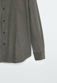 Grijs longsleeve shirt met knoopsluiting, gemaakt van zachte stof, met een gebogen zoom en zichtbare stiksels langs de kraag en manchetten.