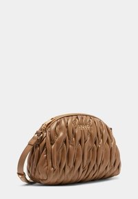 Sac à main en cuir marron avec un design matelassé, forme arrondie et fermeture zippée. Présente un logo doré à l'avant et une bandoulière détachable.