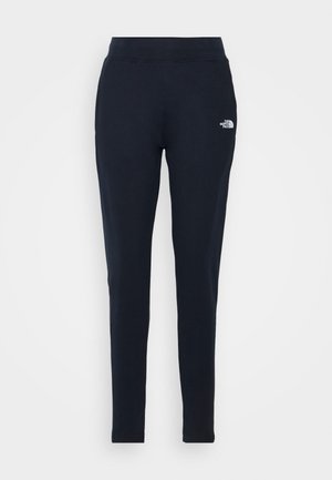 Pantalones jogger azul marino hechos de tela suave, con un diseño ajustado, cintura elástica y un pequeño logo blanco en el muslo izquierdo.