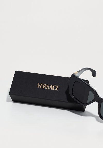 Mustad Versace prillid suurte ristkülikukujuliste läätsedega, läikiva viimistluse ja kuldsete detailidega. Kaasas must karp, millel on reljeefne logo.