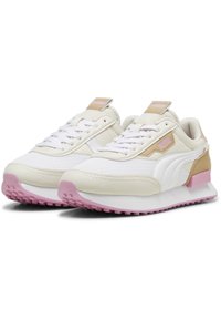 White athletic shoes with light beige accents, textile and synthetic materials, laced front, pink rubber outsole, textured detailing on sides.