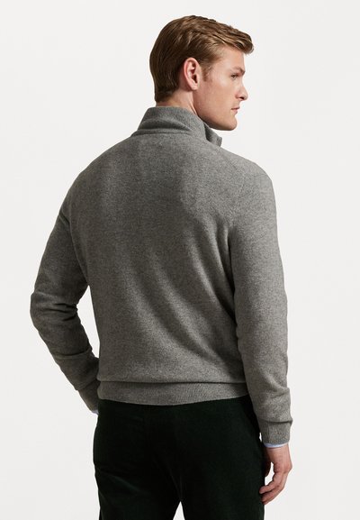 Grå strikket sweater med ombukket krave, ribbede manchetter og kant; glat tekstur; vist fra ryggen med mørke bukser.