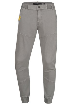 Pantaloni jogger grigi chiari in morbido tessuto, caratterizzati da gambe affusolate, una vita elastica e una tasca laterale con etichetta gialla.