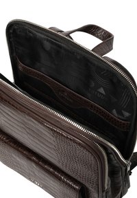 Barna krokodilmintás bőrtáska, cipzárral záródik, dupla fogantyúval, fekete mintás belsővel és tároló zsebekkel.