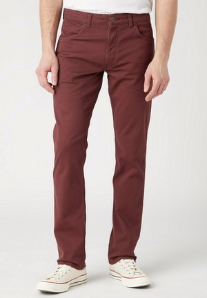 Bordeaux katoenen broek met een taps toelopende pasvorm, vijf-pocket ontwerp en knoopsluiting, gecombineerd met witte sneakers. Glad textuur en casual stijl.