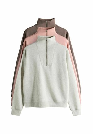 Drie pullovers tentoongesteld: lichtgrijs, roze en donkerbruin. Elke pullover heeft een hoge kraag met een rits aan de voorkant en een zachte textuur.