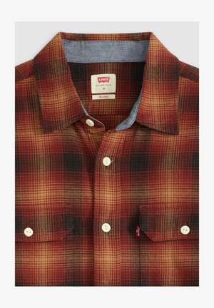 Rood-zwart geruit overhemd met een denim kraag, twee borstzakken met knopen en witte knopen. Label met de tekst "Levi's", maat medium.