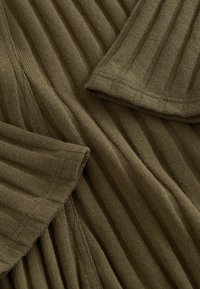 Olivgrüner, gerippter Strickstoff mit vertikalen Streifen, zeichnet sich durch eine glatte Textur und gefaltete Kanten aus und zeigt gestrickte Details.