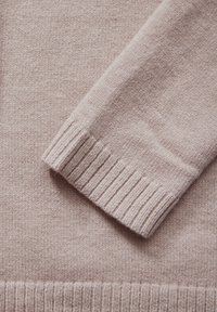 Helles rosa, gestricktes Sweatshirt mit gerippten Bündchen und Saum, das eine weiche Textur und ein klares, einfaches Design zeigt.