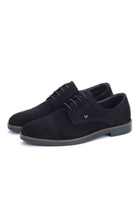 Scarpe da uomo eleganti in suede nero con lacci, bordatura marrone e una sottile cucitura decorativa, mostrate affiancate su uno sfondo bianco.