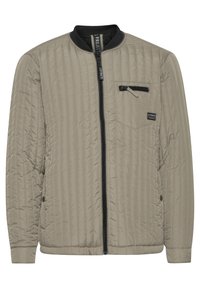 Lightweight taupe bomber jacket with vertical quilting, black zip closure, and a chest pocket featuring a zip and branded tag.