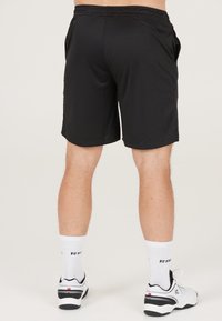 Svarta sportshorts gjorda av lättviktigt material med elastiskt midjeband, sidofickor och en slät yta.