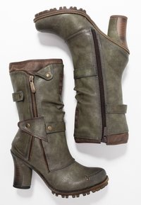 Botines verdes elegantes con un acabado texturizado, que presentan cremalleras, correas decorativas y un tacón resistente. Aptos para un uso casual.