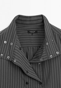 Chemise gris foncé avec fines rayures verticales noires, col montant et boutons-pression, étiquette Massimo Dutti, fabriquée au Maroc.