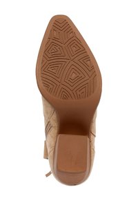 Botín de ante beige con suela de goma, que presenta un patrón texturizado en zigzag, cremallera trasera y un tacón cónico para mayor estabilidad.