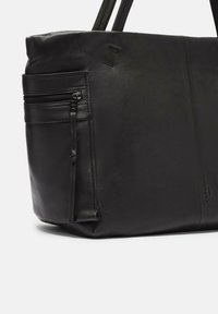 Czarna skórzana torba tote z podwójnymi uchwytami, z jedną zamykaną kieszenią z przodu i gładką teksturą. Wytłoczone logo z boku.