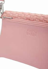 Borsa clutch in pelle rosa con un design intrecciato testurizzato nella parte superiore, chiusura con zip e nome del marchio "Freds Bruder" embossato sul davanti.