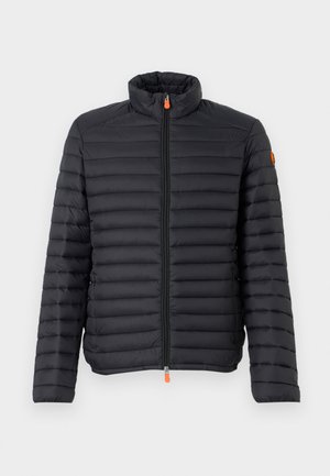 Sort pufferjakke med vandret quiltet design, høj krave, frontlynlås og en kontrasterende orange lynlåsslæb. Blød tekstur.