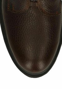 Brown leather shoe with a textured surface, rounded toe, and contrasting orange stitching along the seams. Black rubber sole.