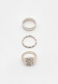 Tre silveringar: en slät ring, en vriden design och en sigillring med en rosengraverad utsmyckning. Alla visade på en vit bakgrund.