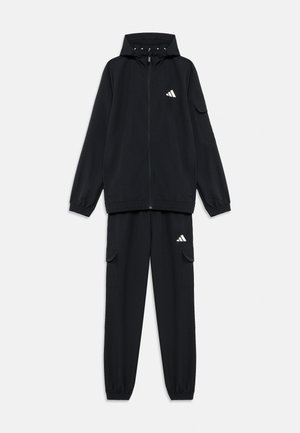 Veste à capuche noire zippée et pantalon cargo assorti avec poignets élastiques, présentant de petits logos Adidas blancs sur la poitrine et la cuisse.